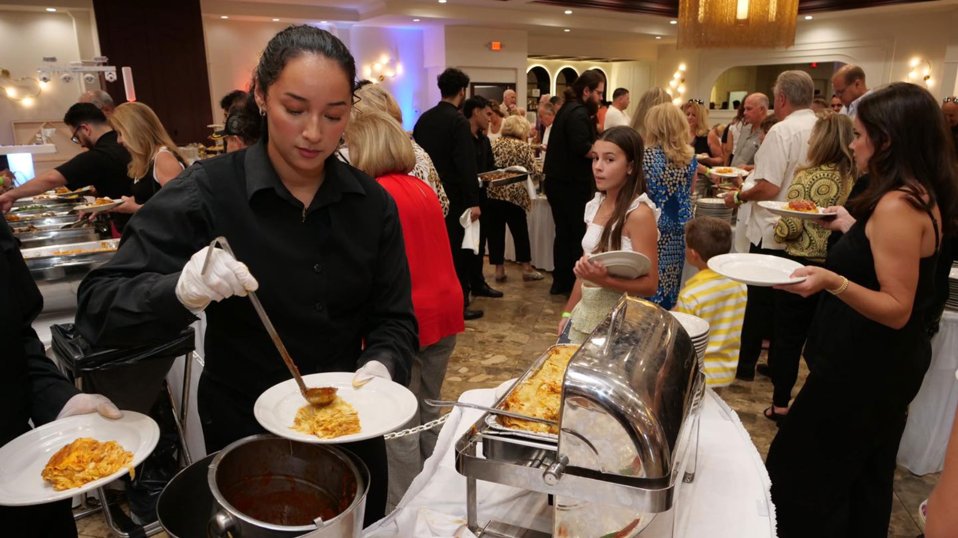 A person serving food at a buffet